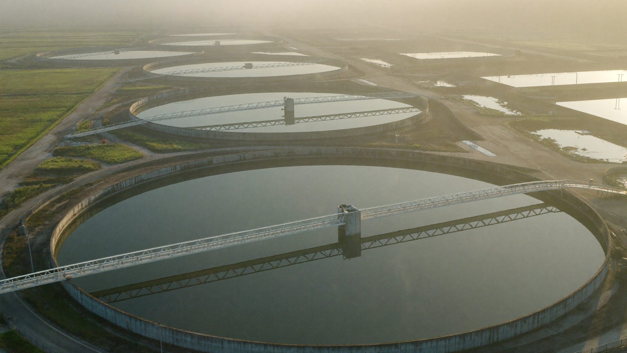 Circular clarifiers at a wastewater treatment plant at first light