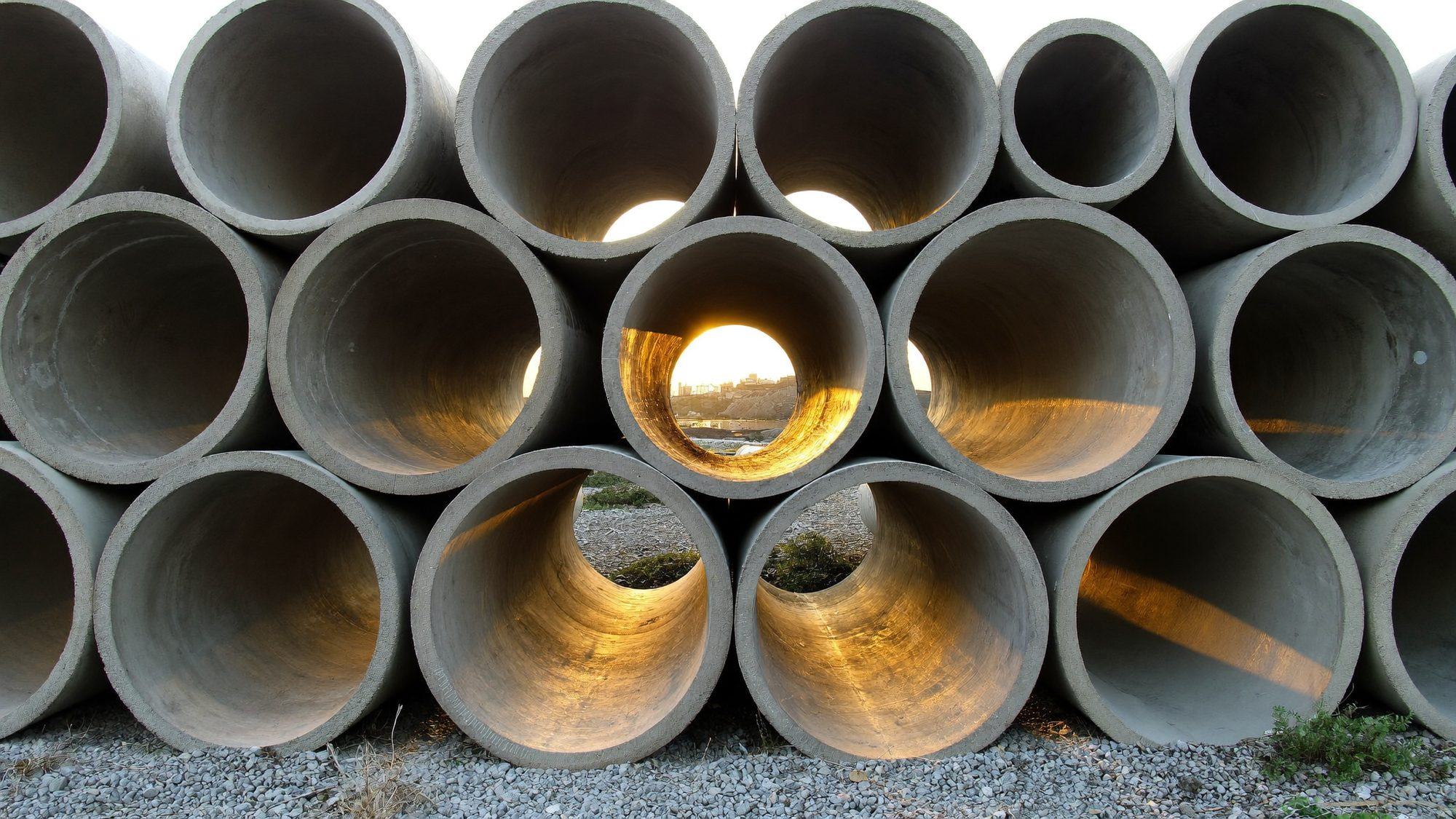 Rows of large concrete pipe sections stacked in a yard
