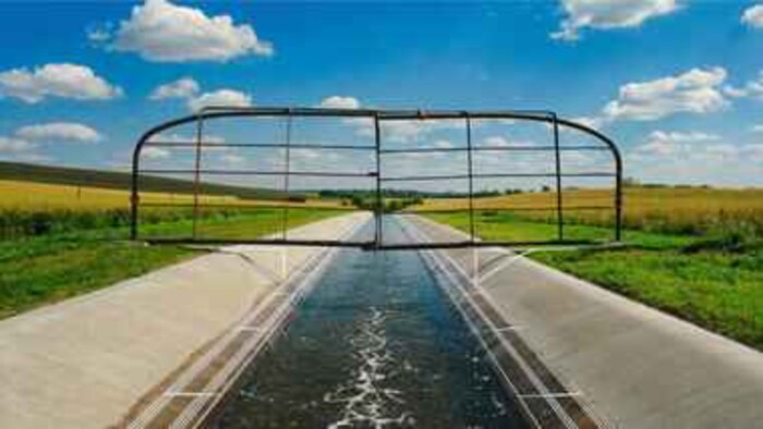 Golden-hour irrigation headgate and canal — illustrating water as an appropriative property right in the West