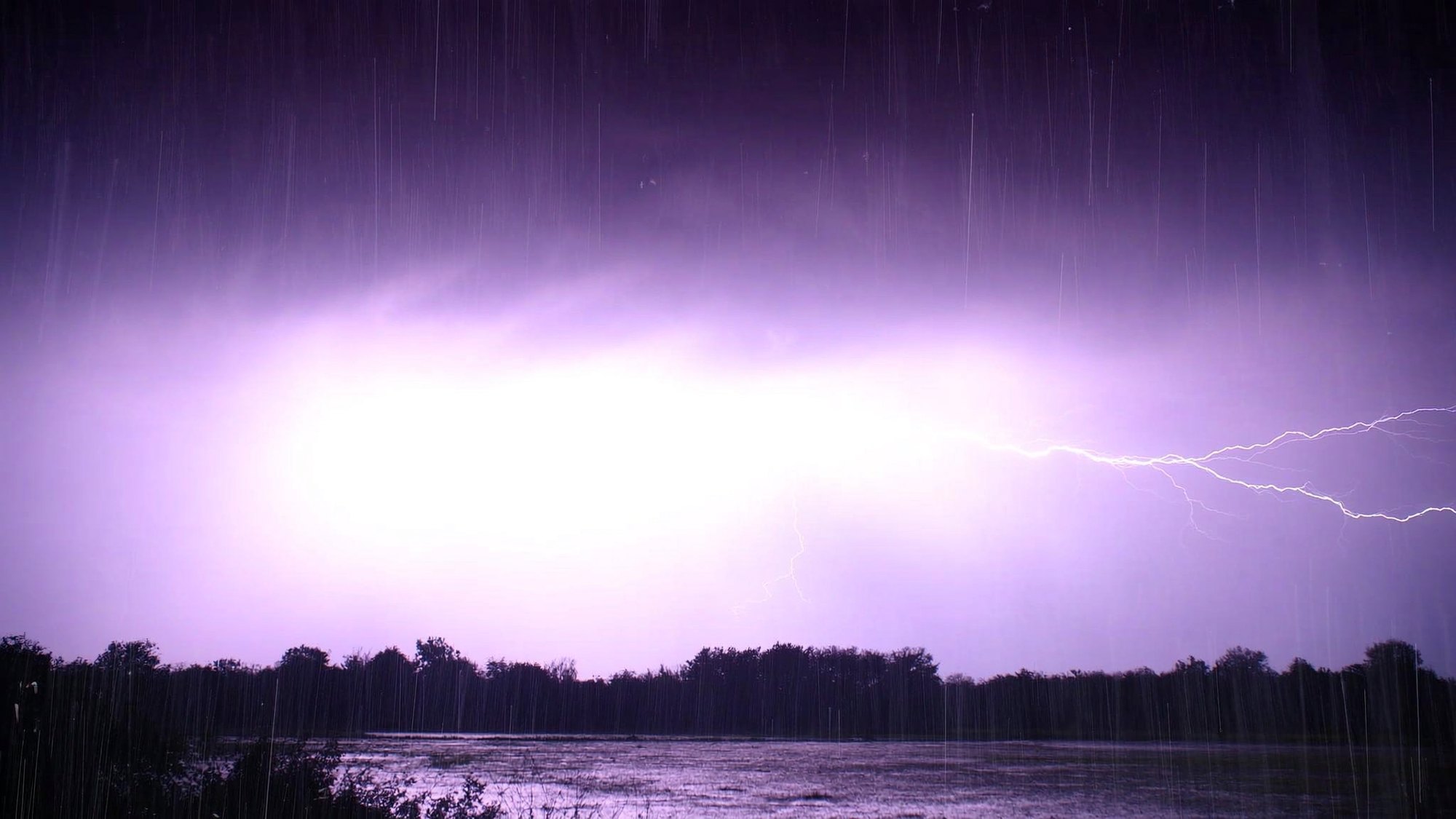 Lightning over a flooded field at night