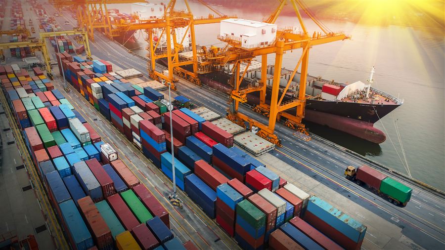 Aerial view of a container shipyard and cranes at sunrise